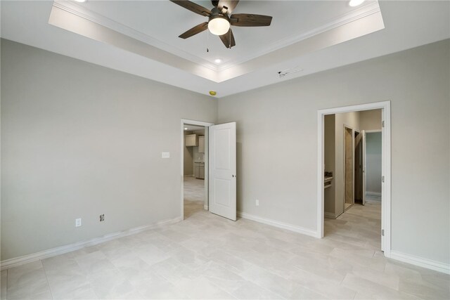 unfurnished bedroom featuring a tray ceiling, ceiling fan, and crown molding