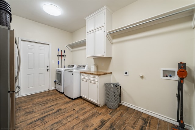 clothes washing area featuring washer / clothes dryer, dark wood-type flooring, and cabinets