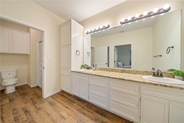 bathroom featuring hardwood / wood-style floors, vanity, and toilet