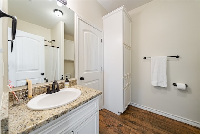 bathroom featuring curtained shower, toilet, vanity, and hardwood / wood-style flooring