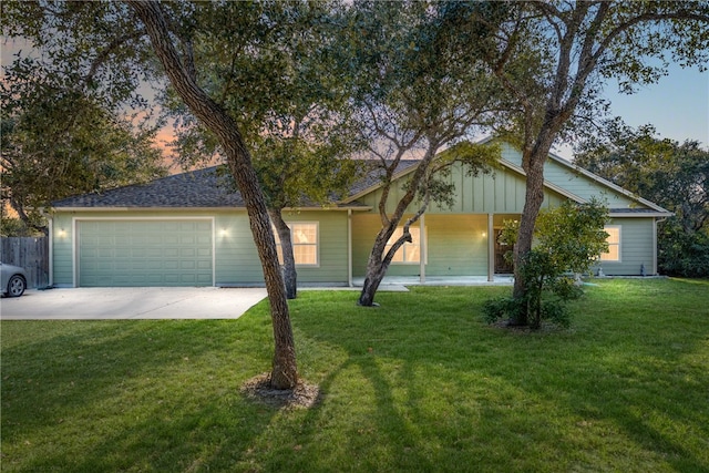 ranch-style home featuring a garage and a yard