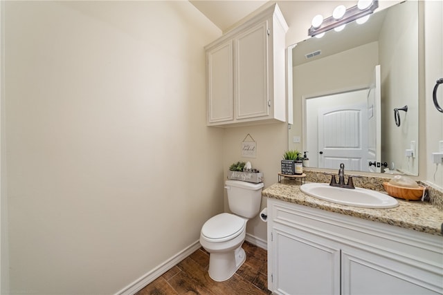 bathroom featuring wood-type flooring, vanity, and toilet