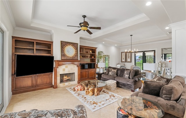 living area featuring visible vents, light tile patterned flooring, a fireplace, a raised ceiling, and ceiling fan with notable chandelier