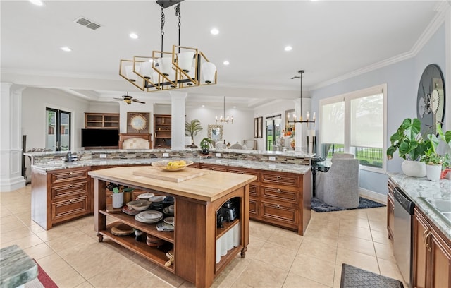 kitchen featuring ornate columns, open shelves, a large island with sink, and brown cabinetry