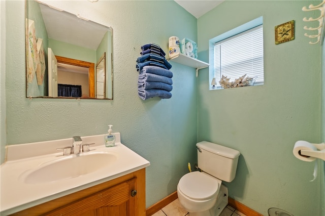 bathroom with toilet, vanity, and tile patterned floors