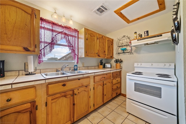 kitchen with sink, light tile patterned floors, tile counters, and white range with electric cooktop