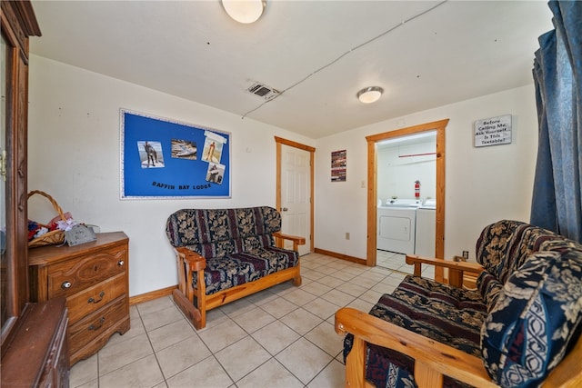 living area with washer and clothes dryer and light tile patterned floors