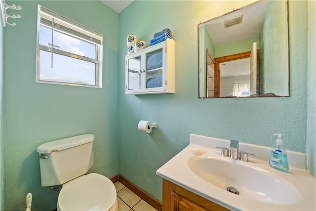 bathroom with toilet, vanity, and tile patterned floors