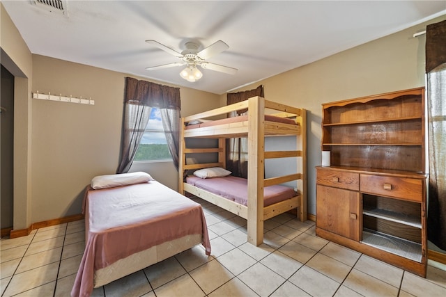 tiled bedroom featuring ceiling fan