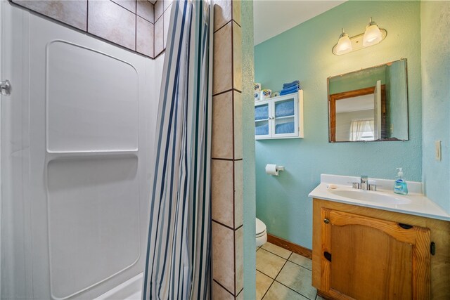 bathroom with toilet, a shower with curtain, vanity, and tile patterned flooring