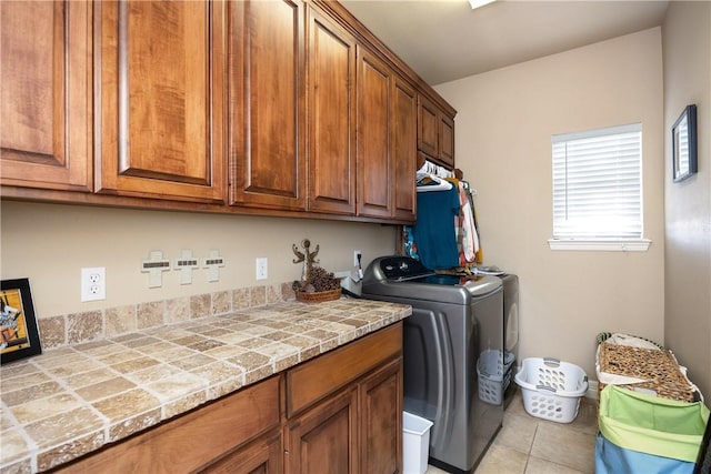 laundry room with cabinets, separate washer and dryer, and light tile patterned flooring