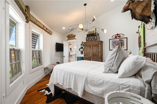 bedroom with a chandelier, dark hardwood / wood-style floors, and vaulted ceiling