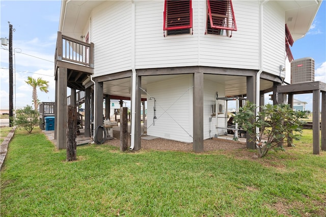 rear view of property with a yard and central AC