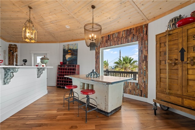 kitchen featuring hanging light fixtures, wooden ceiling, and wood walls