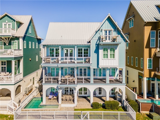 rear view of property featuring a balcony and a patio area