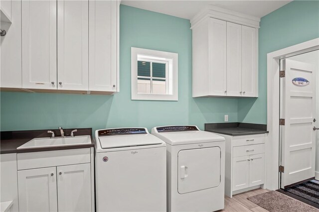 144 Sunrise Ave, Port Aransas, TX 78373 - laundry room featuring cabinet space, light wood-type flooring, and washer and dryer