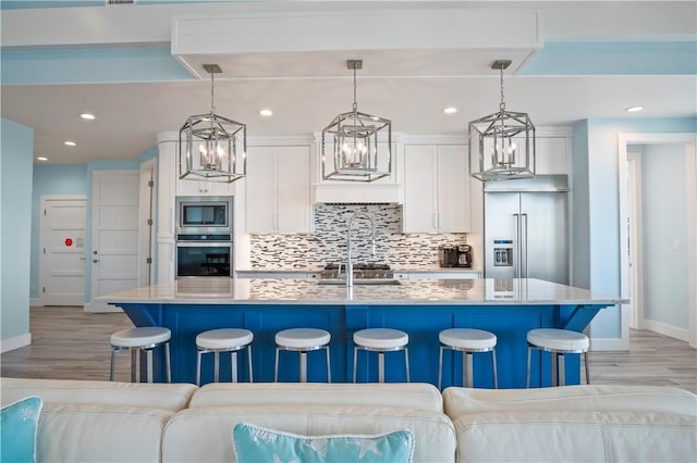 144 Sunrise Ave, Port Aransas, TX 78373 - kitchen with built in appliances, baseboards, light wood-style floors, a kitchen breakfast bar, and recessed lighting