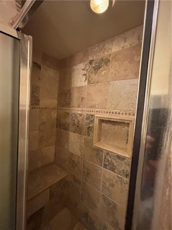 bathroom with a shower with door