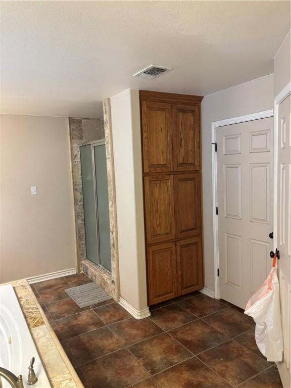 bathroom with tile patterned flooring and an enclosed shower