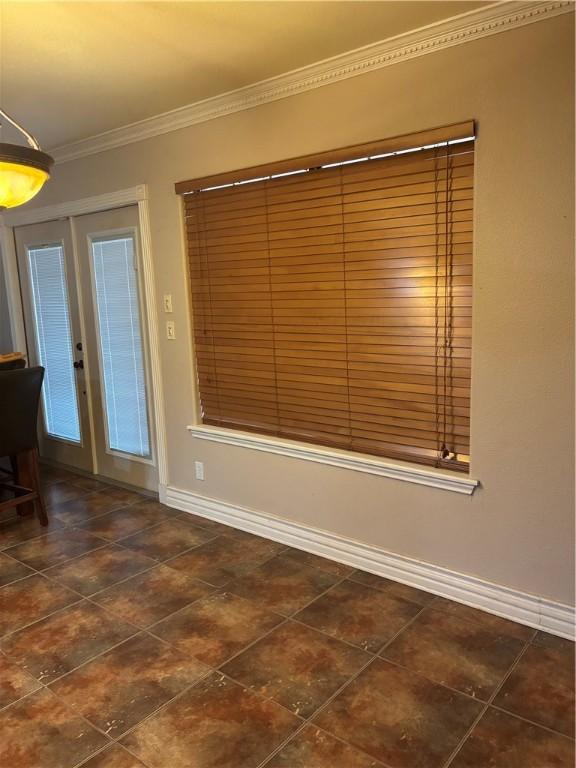 empty room featuring french doors and crown molding