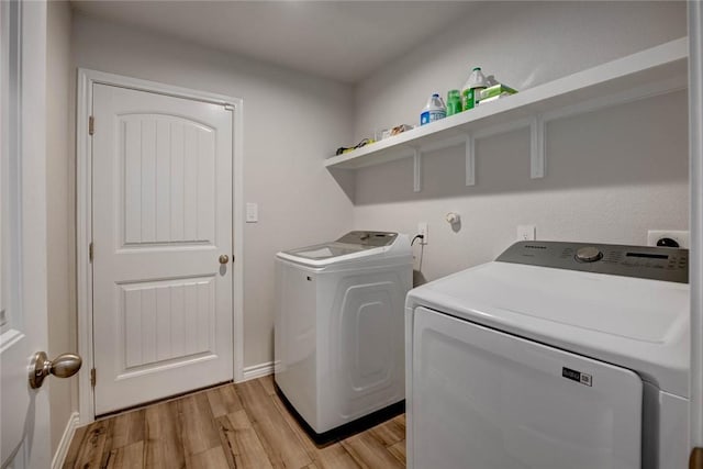 clothes washing area featuring washing machine and dryer and light wood-type flooring