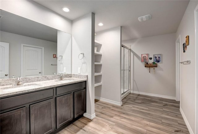 bathroom featuring built in features, vanity, walk in shower, and hardwood / wood-style floors