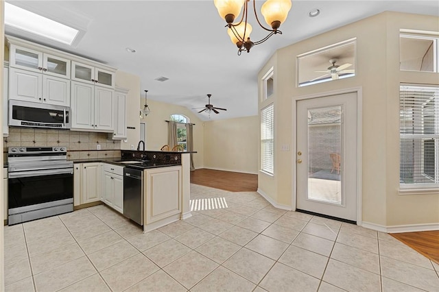 126 Whistlers Cove Rd, Rockport, TX 78382 - kitchen featuring stainless steel appliances, a peninsula, a chandelier, a sink, and ceiling fan