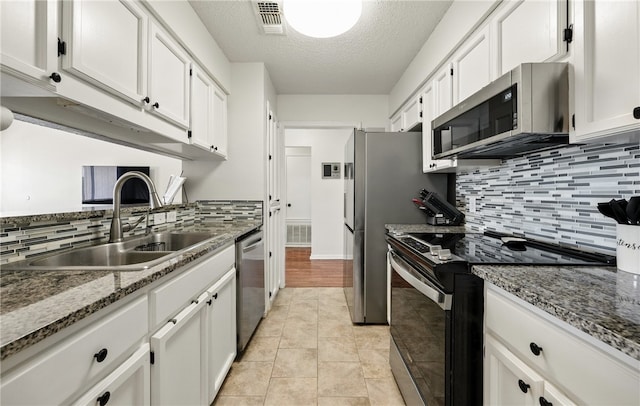 2722 Camargo Dr, Corpus Christi, TX 78415 - kitchen featuring stainless steel appliances, white cabinetry, tasteful backsplash, a textured ceiling, and stone countertops