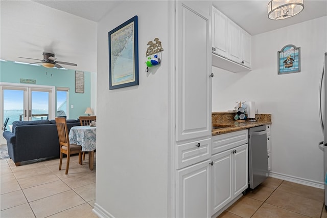 interior space with white cabinets, light tile patterned flooring, and stainless steel dishwasher