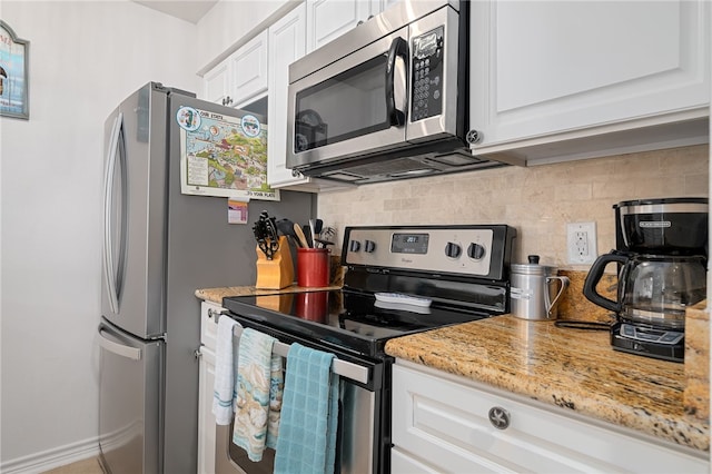 kitchen with white cabinets, decorative backsplash, appliances with stainless steel finishes, and light stone countertops