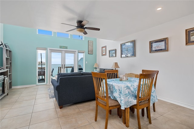 dining space featuring ceiling fan, light tile patterned floors, a water view, and french doors