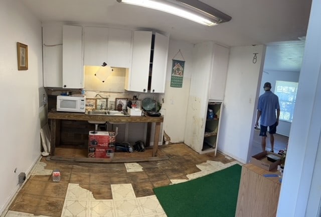 kitchen featuring white cabinetry and sink