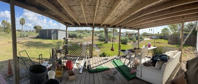 wooden deck featuring a storage shed and a yard