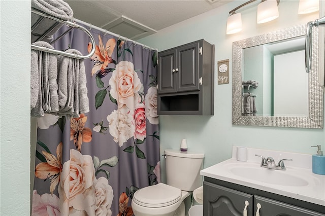 bathroom featuring toilet, a shower with curtain, vanity, and a textured ceiling