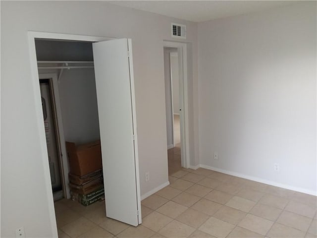 5973 State Highway 361 Unit 121, Port Aransas, TX 78373 - unfurnished bedroom with light tile patterned floors, a closet, and baseboards