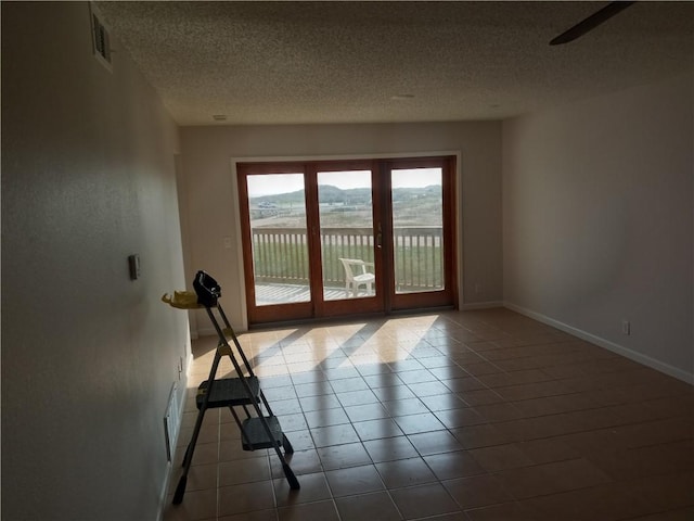5973 State Highway 361 Unit 121, Port Aransas, TX 78373 - tiled empty room featuring a textured ceiling and baseboards