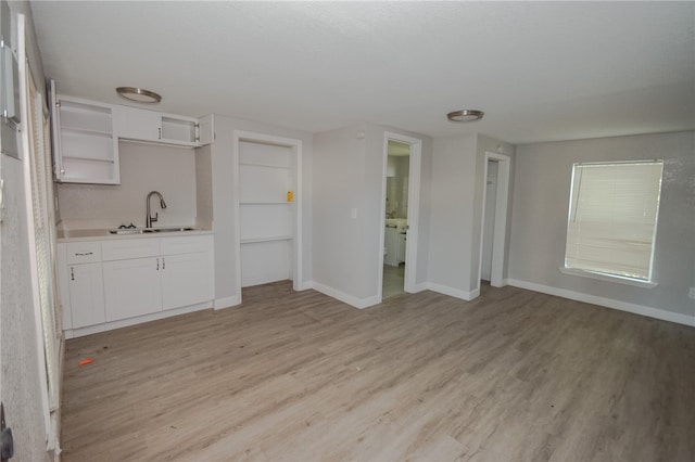 kitchen featuring light hardwood / wood-style floors, white cabinetry, and sink