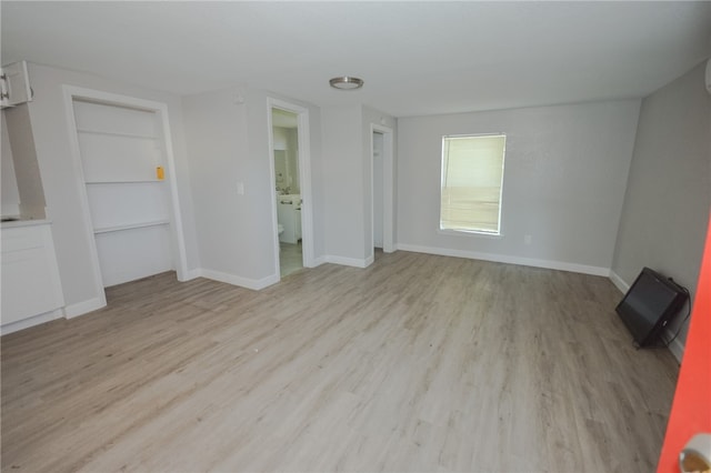 unfurnished living room with light wood-type flooring and built in features