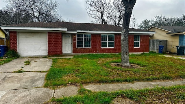 single story home featuring an attached garage, a front yard, concrete driveway, and brick siding