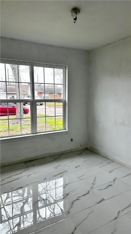 unfurnished room featuring marble finish floor