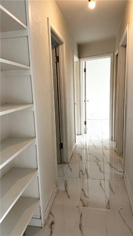 hallway featuring marble finish floor