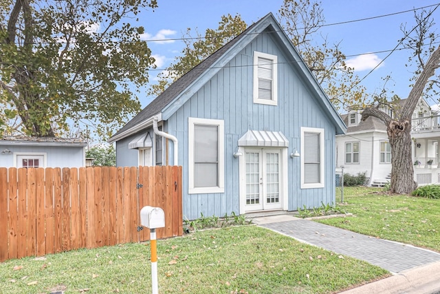 view of front of home with french doors, a front lawn, and fence