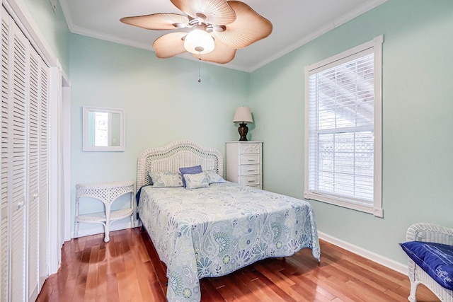 bedroom with a closet, wood finished floors, and ornamental molding