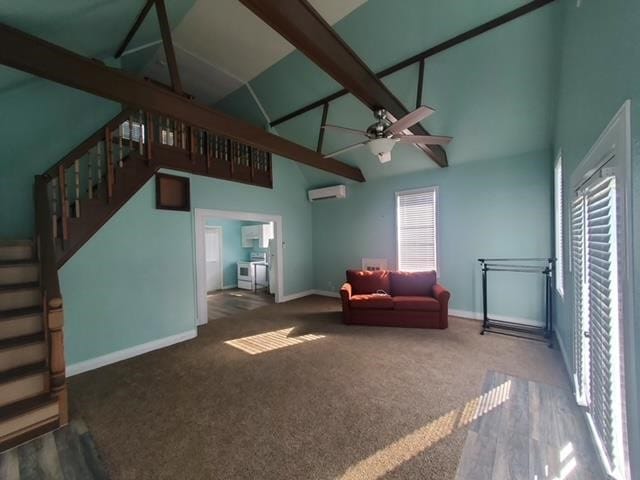 living area with a wealth of natural light, baseboards, a wall unit AC, and carpet floors