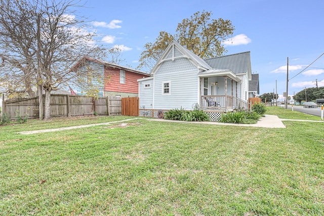 view of side of home with a yard, fence, and metal roof