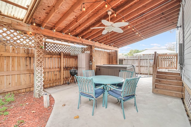 view of patio / terrace featuring ceiling fan, a hot tub, outdoor dining area, and a fenced backyard