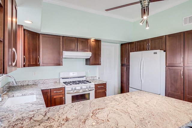 kitchen featuring visible vents, ornamental molding, under cabinet range hood, a sink, and white appliances