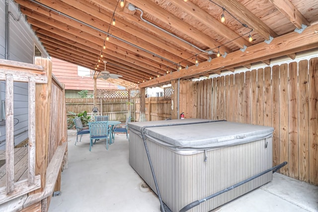 view of patio with outdoor dining area, fence, and a hot tub