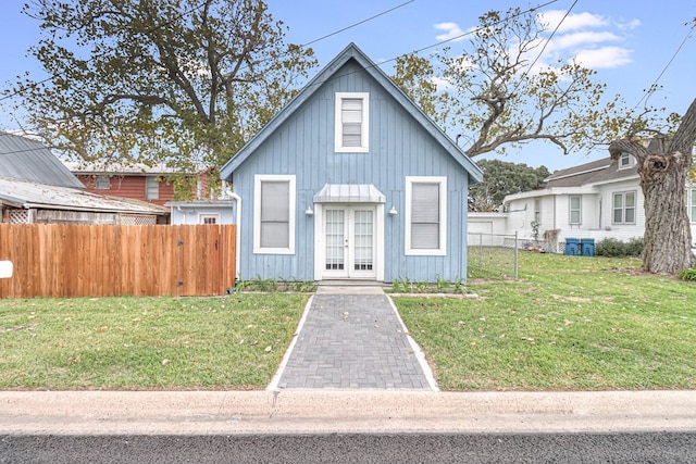 view of front facade featuring a front yard, french doors, and fence