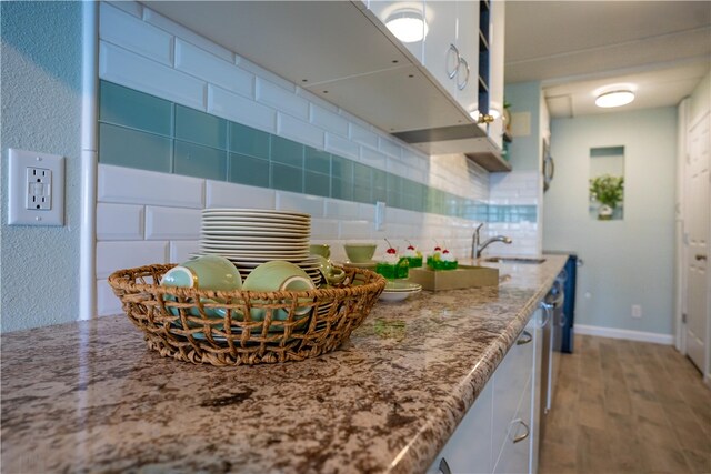 4334 E Ocean Dr Unit 306, Corpus Christi, TX 78404 - kitchen featuring wood finished floors, backsplash, and light stone countertops